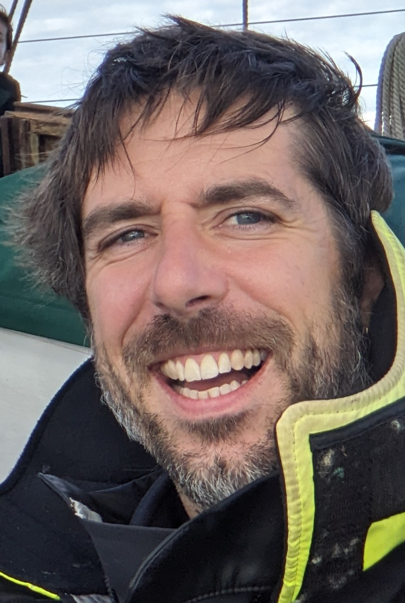 Gabriel smiling aboard a sailboat.