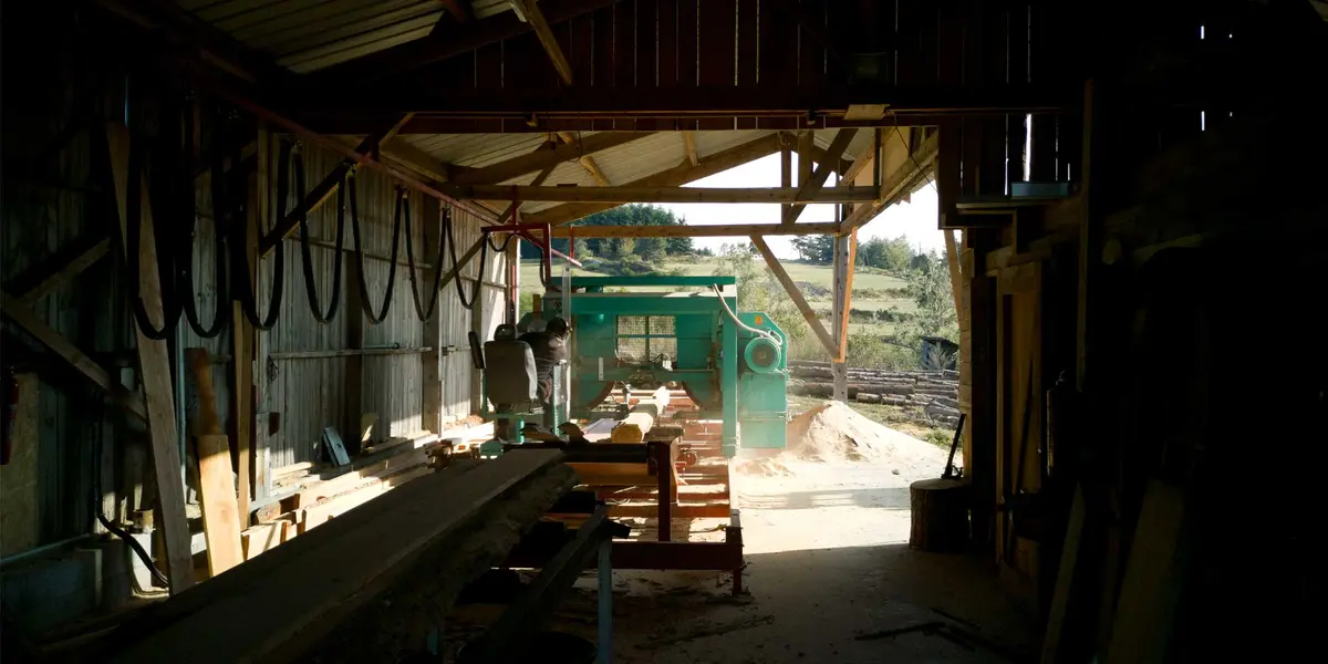 Timber and sawmill machinery inside the Noz’Ateliers workshop.
